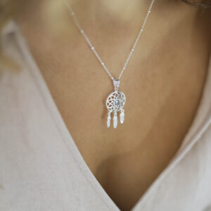 silver dangly dream catcher necklace with centre blue topaz on model