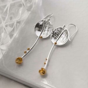 silver and gold disc and stars dangly earrings laid on tile