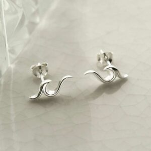 silver ocean waves stud earrings on tile