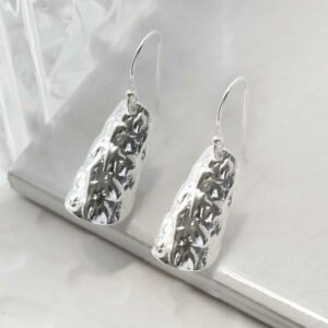 silver pine bark textured earrings on tile