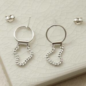 silver curb chain hanging from ring earrings laid