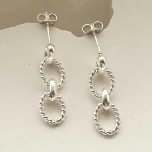 silver three link braided chain earrings laid