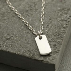 small silver dog tag on slate stone