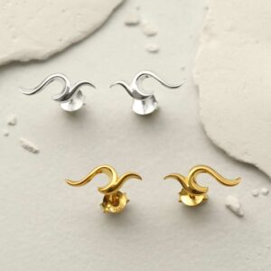 silver and gold flame stud earrings on tile