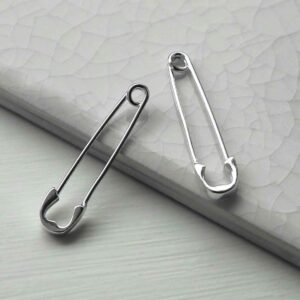 sterling silver long safety pin earrings learning on white tile