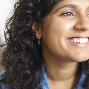 Model Wearing Large Safety Pin Earrings with denim jacket