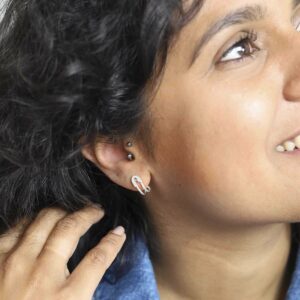 Model wearing safety pin hug studs in denim jacket