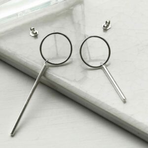 silver mismatch ring and bar stud drop earrings on tile