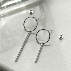 silver mismatch ring and bar stud drop earrings on tile