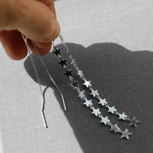 silver ten stars dangling from box chain threader earrings held in shade