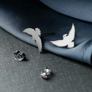 silver bird stud earrings on cloth