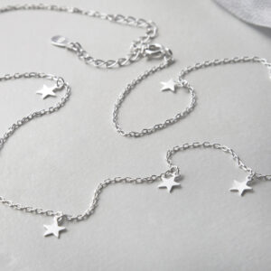 silver tiny stars on chain necklace strewn on stone