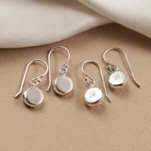 silver plain round dangly earrings and silver engraved round dangly earrings on beige