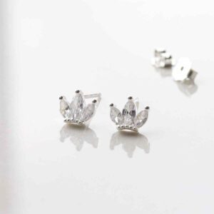 silver crown studs with cubic zirconia stone in centre on marble tile in sunlight