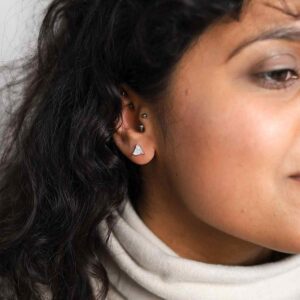 model wearing silver triangle gemstone studs