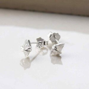 silver diamond shaped cubic zirconia studs with wrapped wire strewn on tile