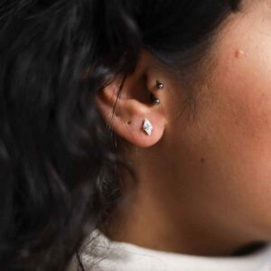 model wearing silver wire wrapped diamond shaped gemstone studs