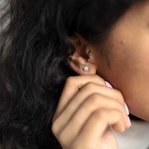 model wearing silver star studs with clear gemstone