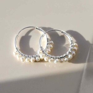 silver hoops with rows of pearls strewn on tile