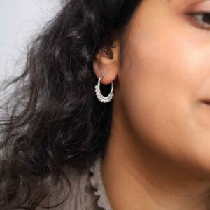 model wearing silver hoops with rows of pearls along them