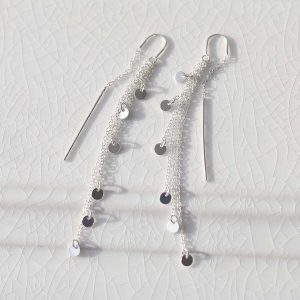 Cascading Coins Threader Earrings on white marble background