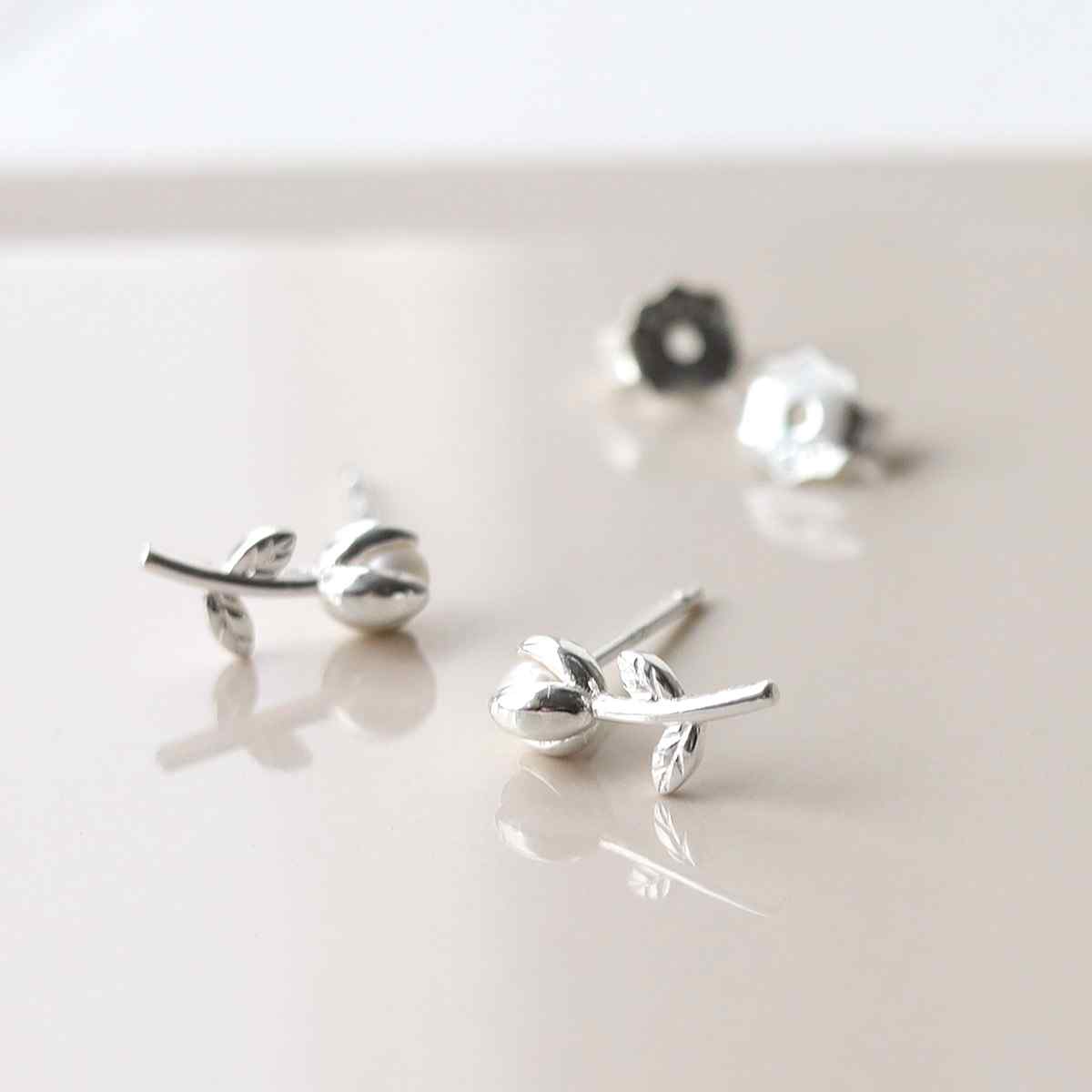 silver tiny basic tulip studs taken apart on tile