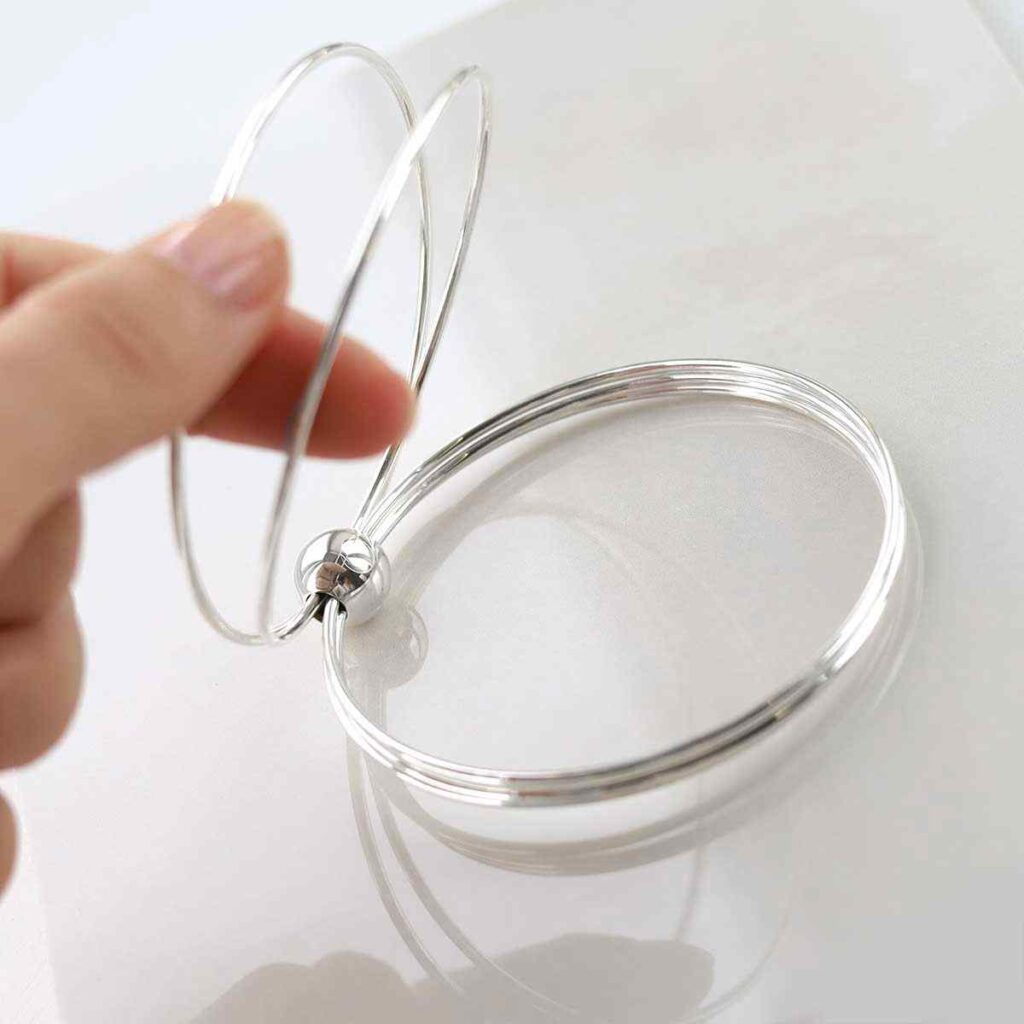 silver bangle with bead on multiple strands design held up