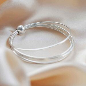 silver bangle with bead on multiple strands design on silk