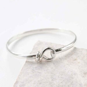 sterling silver knot bangle on the edge of tile