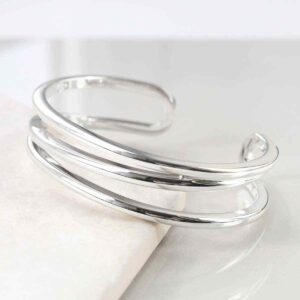 sterling silver wrap cuff bangle leaning on tile