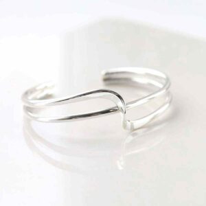 silver crossover bands design cuff bangle on white tile