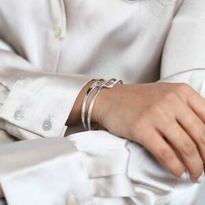 model wearing silver crossover bands design cuff bangle