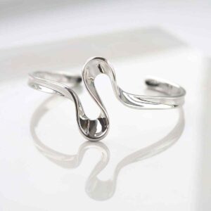 silver curling ribbon design bangle on white shining surface