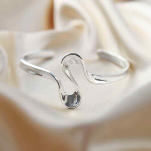 silver curling ribbon design bangle on silk