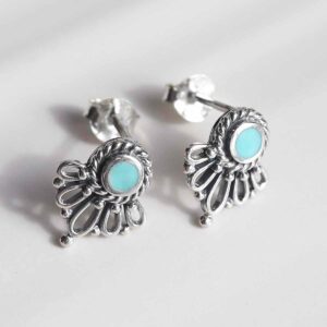 sterling silver ornate turquoise stud earrings on ceramic background