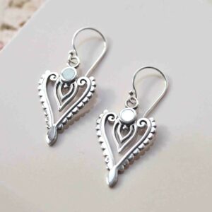 sterling silver mother of pearl arrow earrings on ceramic background