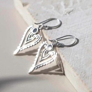 sterling silver onyx arrow earrings ceramic and paint background