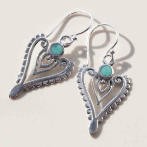 sterling silver turquoise arrow earrings on ceramic background