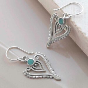 sterling silver turquoise arrow earrings on ceramic background