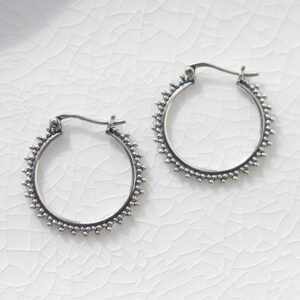 Sterling Silver Large Circle Detail Hoops on ceramic background