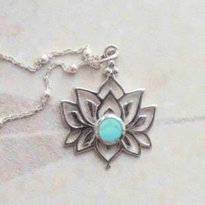 Turquoise Lotus Pendant Necklace on ceramic background