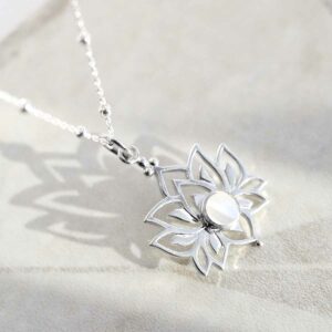 Mother of Pearl Lotus Pendant Necklace on Ceramic background with satellite chain