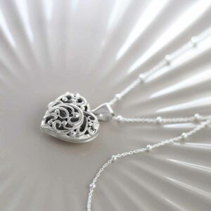 Sterling Silver Fleur De Lis Locket on ceramic background