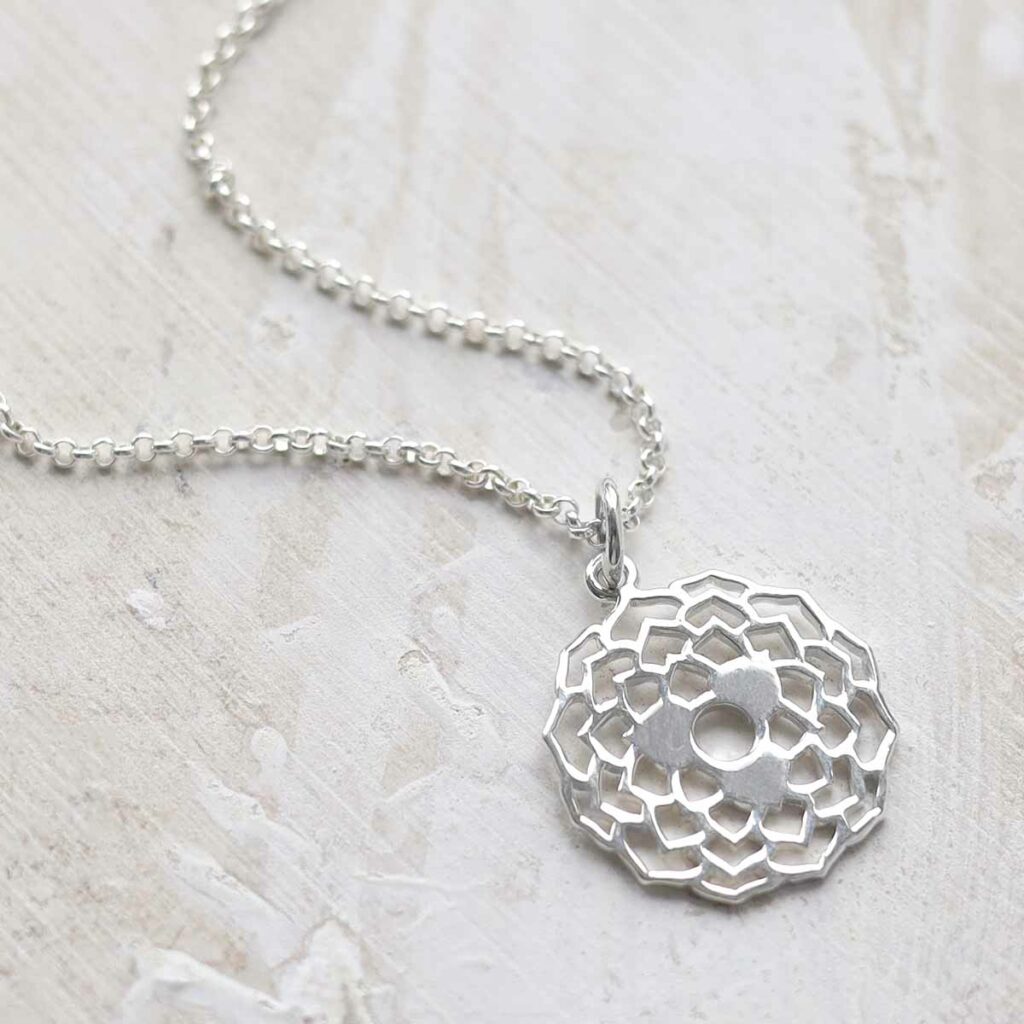 Sterling Silver Dahlia Pendant Necklace on paint and ceramic