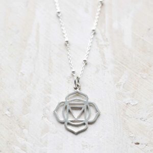 Sterling Silver Large Root Chakra Pendant Necklace on ceramic and paint background