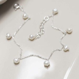 Sterling Silver String of Pearls Bracelet on ceramic background flat