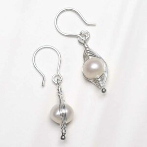 Sterling Silver Pearl Wire Dangly Earrings on textured ceramic background