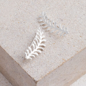 Sterling Silver Vine Ear Climber on cream background.