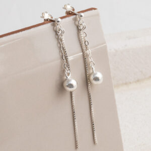 Sterling Silver Round Box and Ball Studs on a cream tile background.