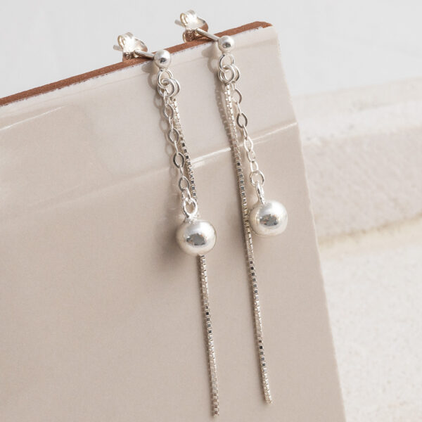 Sterling Silver Round Box and Ball Studs on a cream tile background.